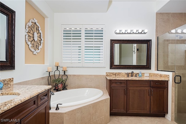 bathroom with a bath, a stall shower, two vanities, and a sink