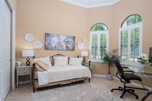 bedroom with ornamental molding, a high ceiling, baseboards, and multiple windows