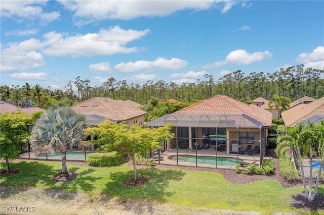 rear view of property featuring a patio area, glass enclosure, an outdoor pool, a yard, and a tile roof