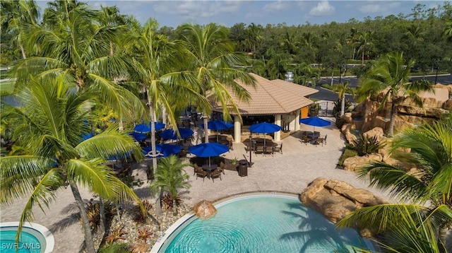 community pool with a gazebo, outdoor dining space, and a patio