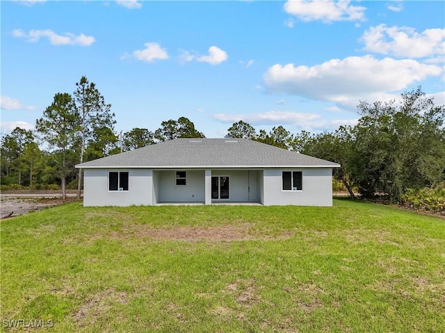 back of property featuring a yard and stucco siding