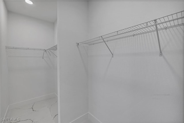 walk in closet with marble finish floor