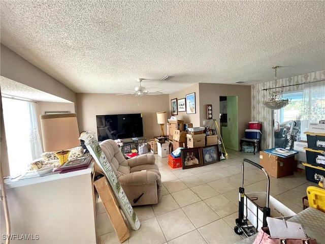 living area featuring a textured ceiling, a ceiling fan, light tile patterned floors, and visible vents