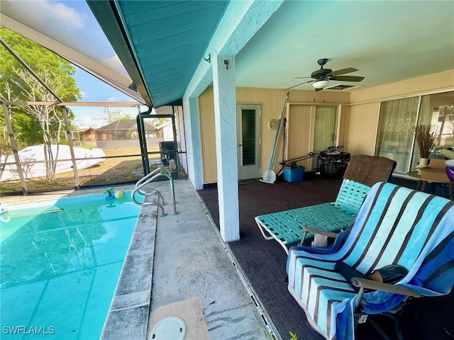 view of patio / terrace featuring glass enclosure, a fenced in pool, and ceiling fan