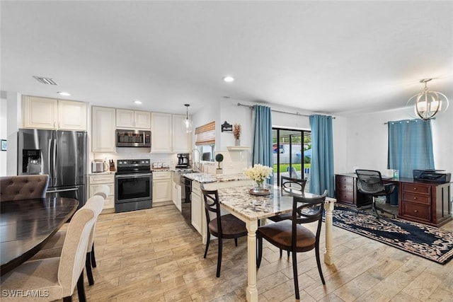 2080 39th St SW, Naples, FL 34117 - kitchen featuring appliances with stainless steel finishes, light wood-type flooring, hanging light fixtures, an office area, and a chandelier
