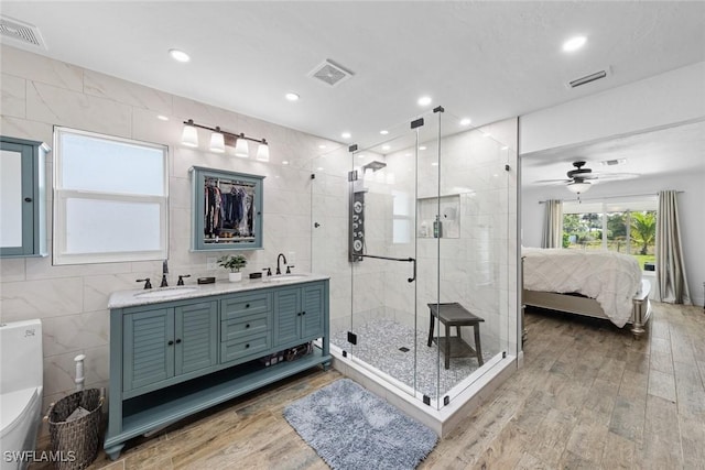 2080 39th St SW, Naples, FL 34117 - bathroom with connected bathroom, tile walls, a stall shower, wood finished floors, and double vanity