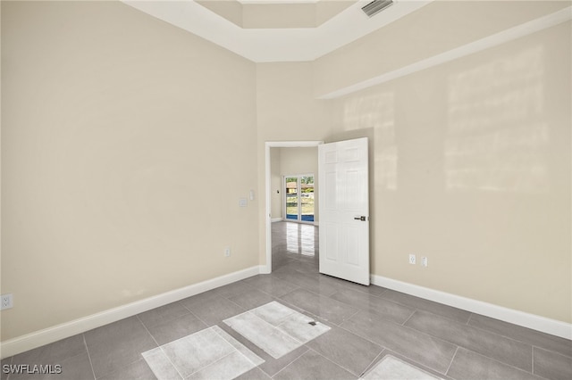 1043 Albert Ave, Lehigh Acres, FL 33971 - tiled spare room featuring baseboards, a high ceiling, and visible vents