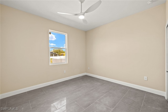 1043 Albert Ave, Lehigh Acres, FL 33971 - spare room featuring baseboards, ceiling fan, and dark tile patterned flooring