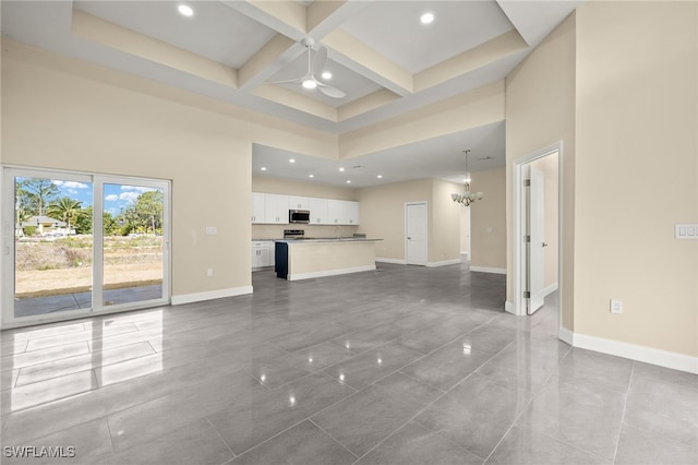1043 Albert Ave, Lehigh Acres, FL 33971 - unfurnished living room featuring a towering ceiling, beam ceiling, baseboards, coffered ceiling, and ceiling fan with notable chandelier