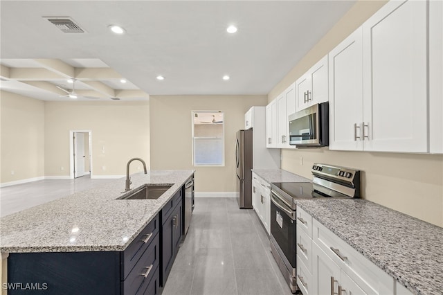 1043 Albert Ave, Lehigh Acres, FL 33971 - kitchen with visible vents, appliances with stainless steel finishes, a sink, white cabinetry, and an island with sink