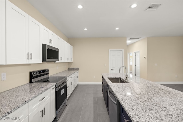 1043 Albert Ave, Lehigh Acres, FL 33971 - kitchen featuring light stone countertops, a sink, stainless steel appliances, white cabinetry, and visible vents