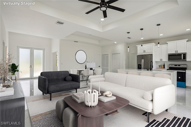 living area with visible vents, recessed lighting, a tray ceiling, french doors, and a ceiling fan
