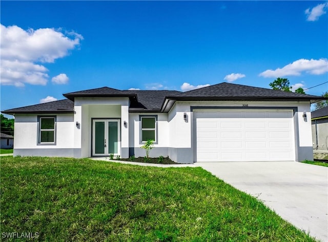 prairie-style home with driveway, french doors, a front lawn, an attached garage, and stucco siding