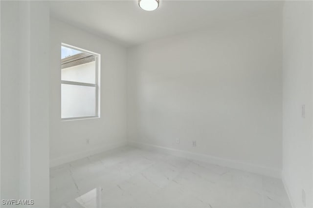 empty room with baseboards and marble finish floor