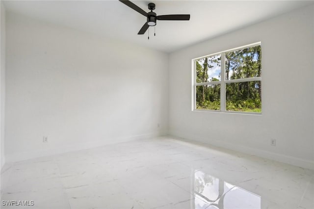 empty room featuring baseboards, a ceiling fan, and marble finish floor