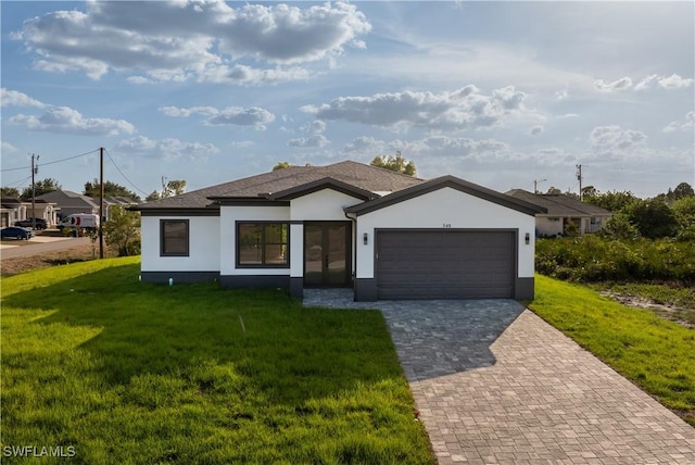 view of front of home featuring decorative driveway, a garage, stucco siding, and a front yard