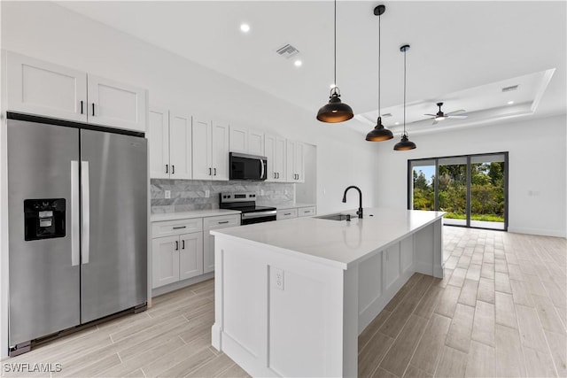 kitchen with ceiling fan, backsplash, visible vents, appliances with stainless steel finishes, and a sink