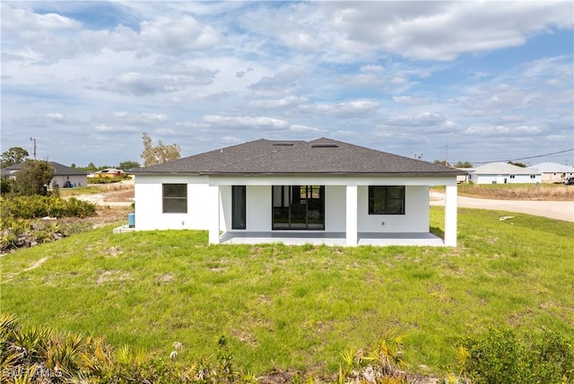 rear view of property featuring a patio area, stucco siding, and a yard