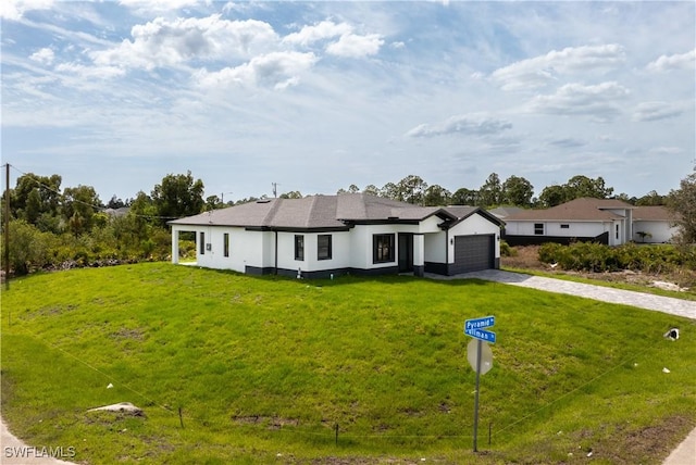 view of front of house with decorative driveway, an attached garage, and a front lawn