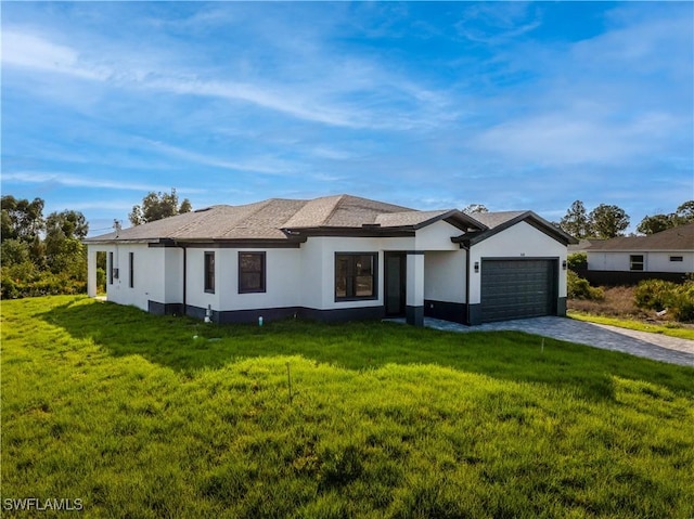 view of front facade featuring a garage, driveway, a front yard, and stucco siding
