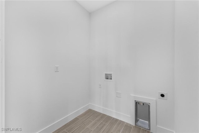 washroom featuring wood finish floors, laundry area, hookup for a washing machine, baseboards, and hookup for an electric dryer