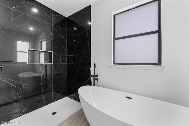 full bathroom featuring a marble finish shower, a soaking tub, and wood finished floors