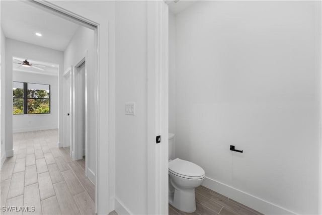 bathroom featuring wood tiled floor, ceiling fan, baseboards, toilet, and recessed lighting