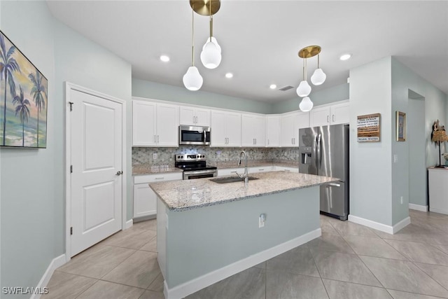 kitchen with a sink, backsplash, white cabinets, and stainless steel appliances