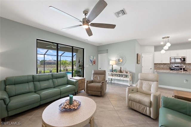 living room featuring light tile patterned floors, ceiling fan, and visible vents