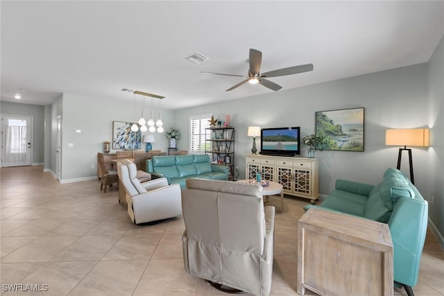 living area with baseboards, ceiling fan, visible vents, and light tile patterned floors