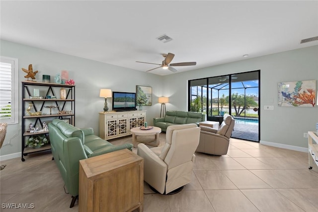 living room featuring visible vents, a ceiling fan, baseboards, and light tile patterned floors
