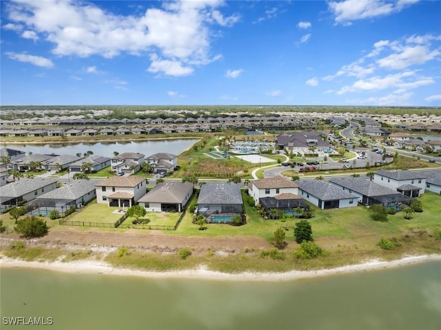 drone / aerial view featuring a residential view, a beach view, and a water view