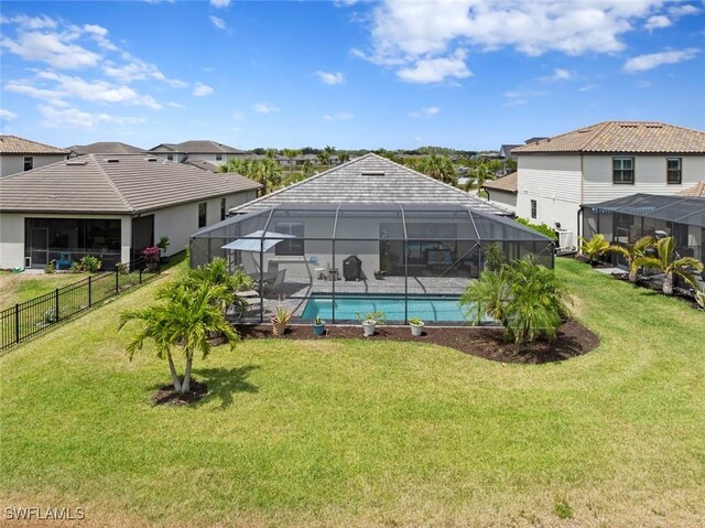 view of swimming pool featuring fence, a fenced in pool, glass enclosure, and a lawn