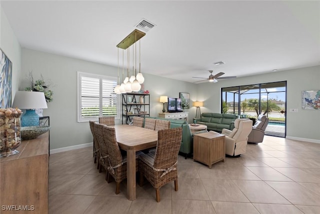 dining area with light tile patterned flooring, ceiling fan, visible vents, and baseboards