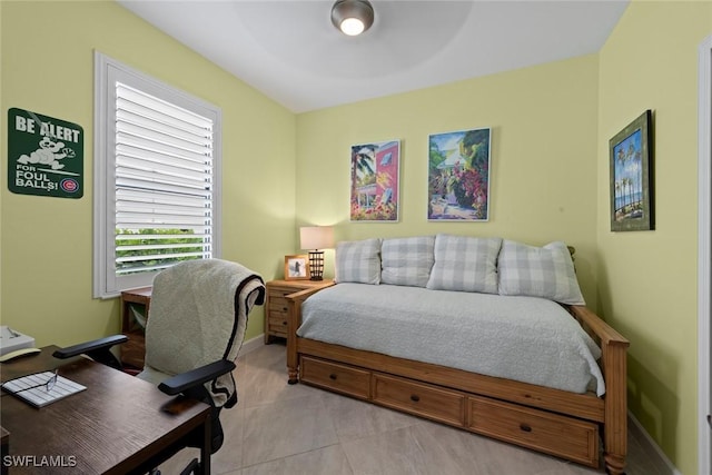 bedroom featuring baseboards, light tile patterned floors, and multiple windows