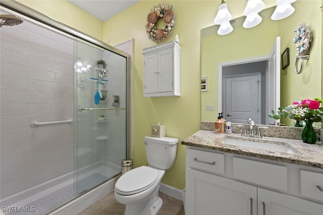 bathroom featuring vanity, toilet, baseboards, and a stall shower