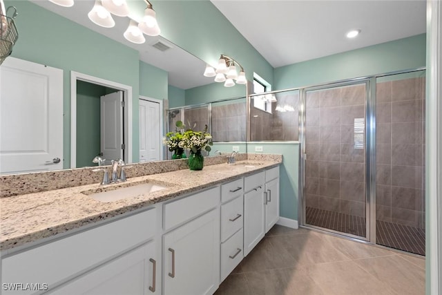 bathroom with double vanity, a sink, tile patterned floors, and a shower stall