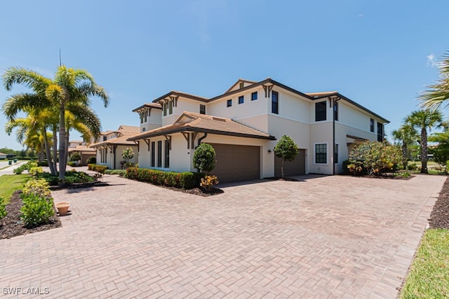 2173 Frangipani Cir Unit 102, Naples, FL 34120 - view of front facade with stucco siding, decorative driveway, and a garage