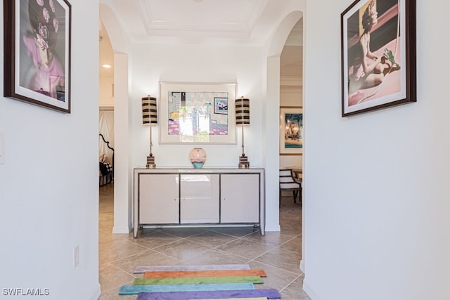 2173 Frangipani Cir Unit 102, Naples, FL 34120 - hall with arched walkways, a tray ceiling, ornamental molding, baseboards, and tile patterned flooring