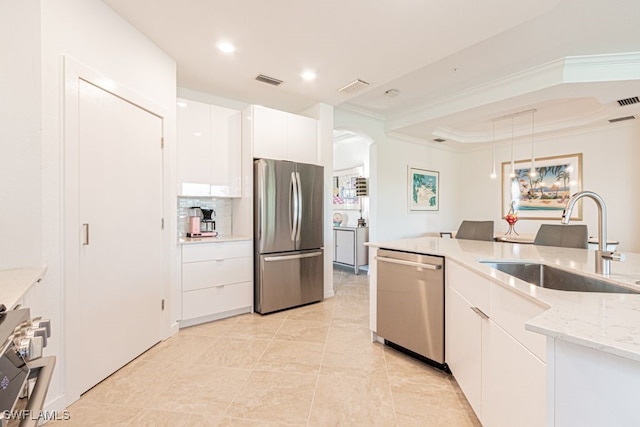 2173 Frangipani Cir Unit 102, Naples, FL 34120 - kitchen featuring stainless steel appliances, a sink, arched walkways, white cabinetry, and hanging light fixtures