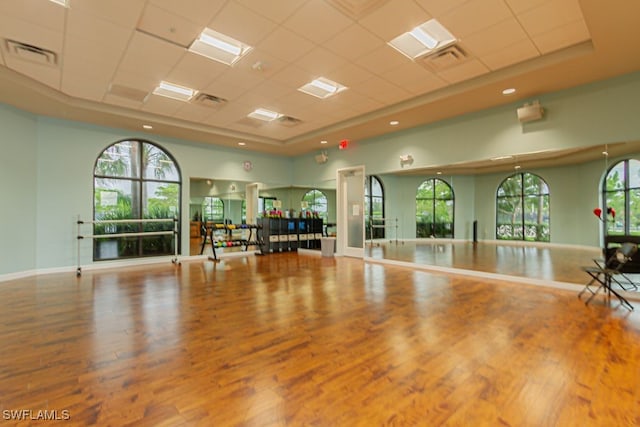 2173 Frangipani Cir Unit 102, Naples, FL 34120 - exercise area featuring a paneled ceiling, wood finished floors, and baseboards