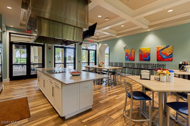 2173 Frangipani Cir Unit 102, Naples, FL 34120 - kitchen with white cabinets, arched walkways, light wood finished floors, beamed ceiling, and coffered ceiling