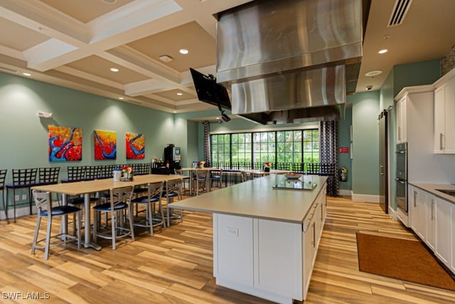 2173 Frangipani Cir Unit 102, Naples, FL 34120 - kitchen with light wood finished floors, white cabinetry, a kitchen island, coffered ceiling, and beamed ceiling