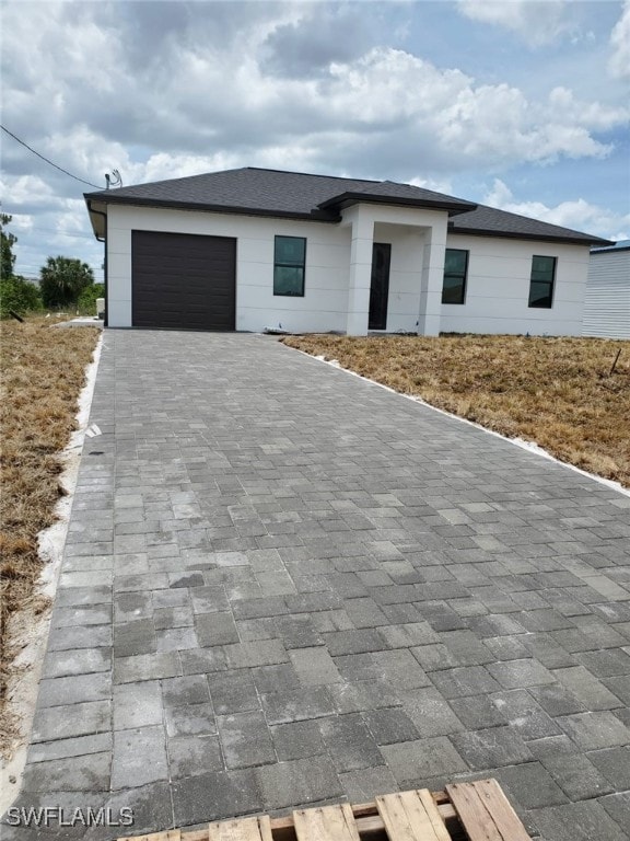 prairie-style house with an attached garage and decorative driveway