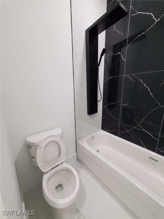 3117 35th St SW, Lehigh Acres, FL 33976 - bathroom featuring toilet, tub / shower combination, and baseboards