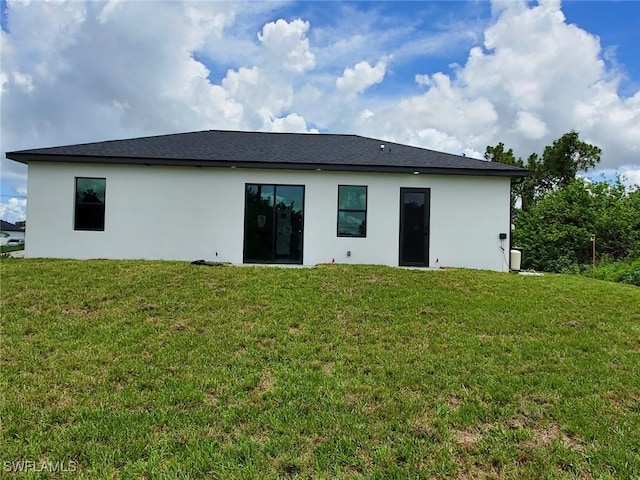 3117 35th St SW, Lehigh Acres, FL 33976 - back of property featuring stucco siding and a yard