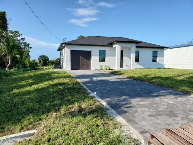3117 35th St SW, Lehigh Acres, FL 33976 - view of front of house featuring a garage, a front yard, decorative driveway, and stucco siding