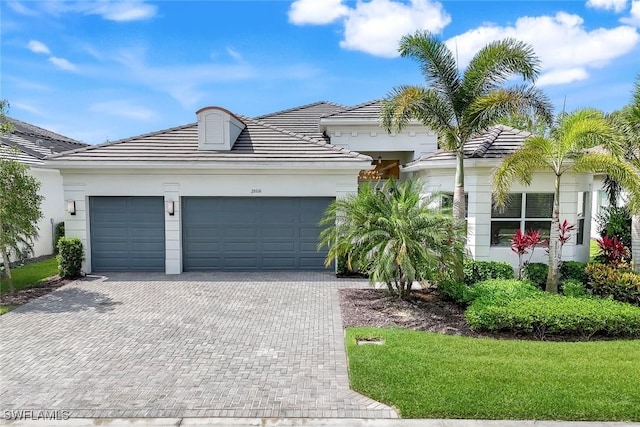 28616 Wharton Dr, Bonita Springs, FL 34135 - view of front of house featuring driveway, an attached garage, a tile roof, and stucco siding