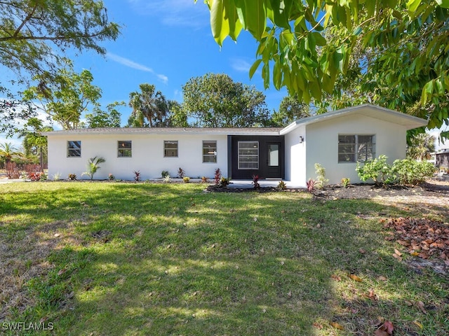 ranch-style house featuring stucco siding and a front yard