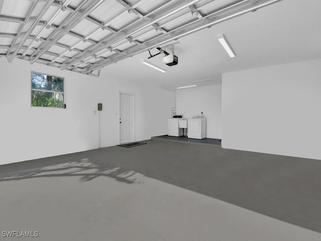 garage featuring separate washer and dryer and a garage door opener